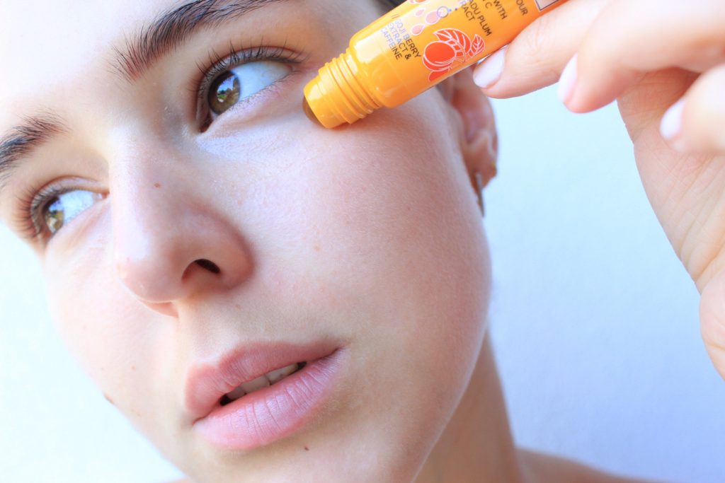 Woman applying eye cream to her under eye area