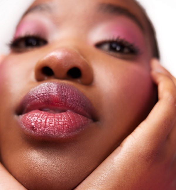 Model wearing pink makeup and a pink lip tint with a close up of the lips. 
